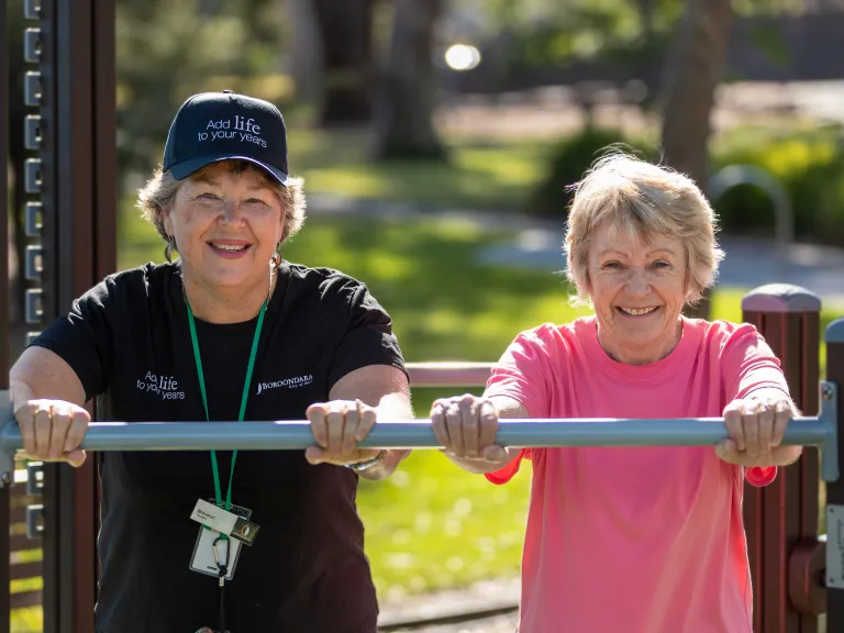 Two women using exercise equipment.