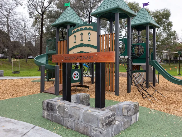 A wooden, child's climbing play unit shaped like a castle