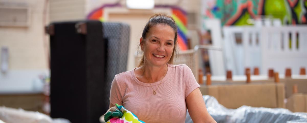 You Matter volunteer Edwina Aikman holds a colourful pillow and smiles at the camera