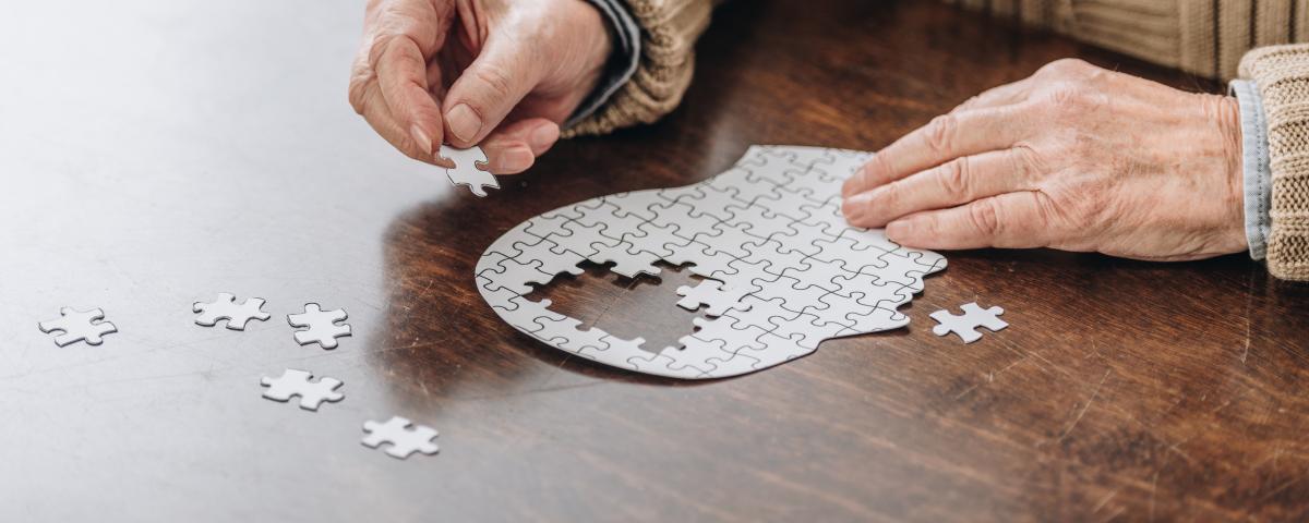 An older man doing a jigsaw puzzle of a mind