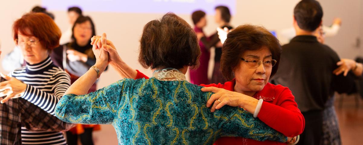 A group of older people dancing in couples on a dancefloor