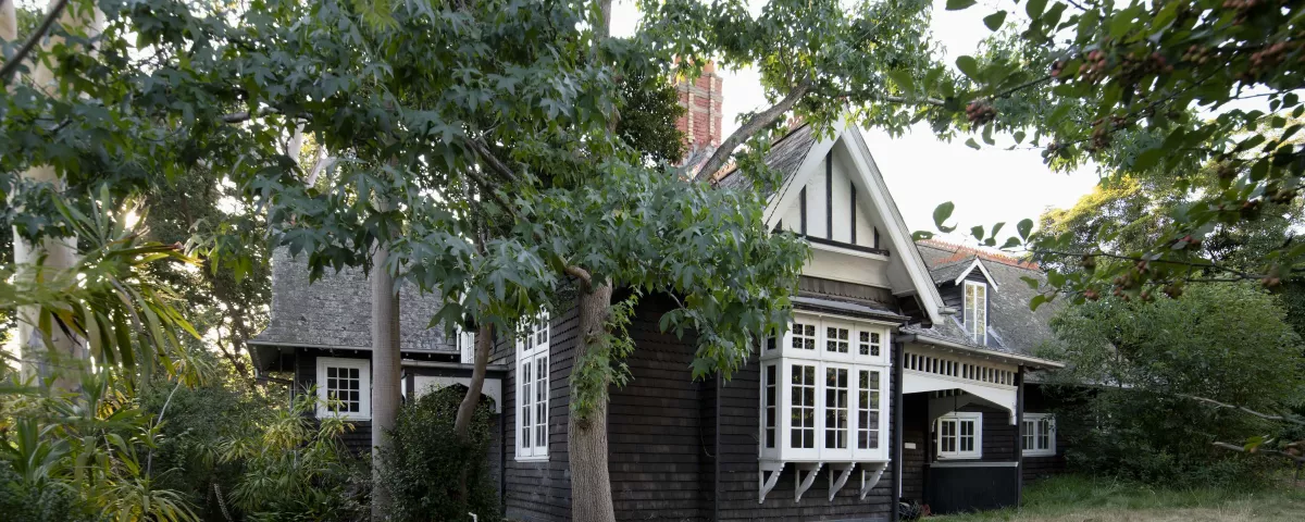 large historic weatherboard house surrounded by trees