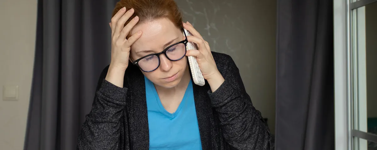 Woman looks distressed while talking on phone