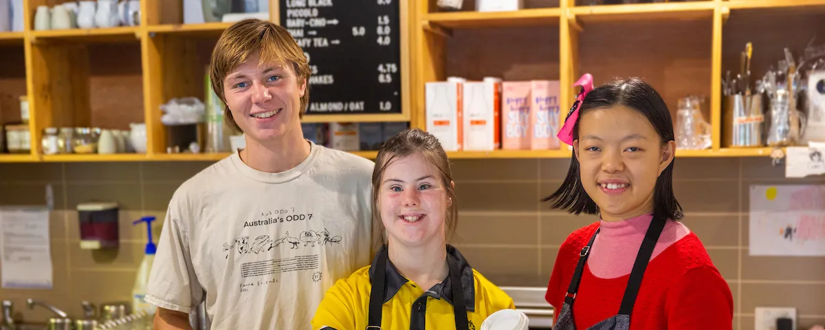 3 young people behind the counter of a cafe 