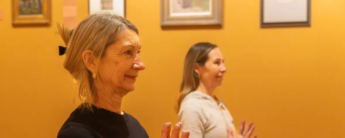 Two women doing yoga in an art gallery
