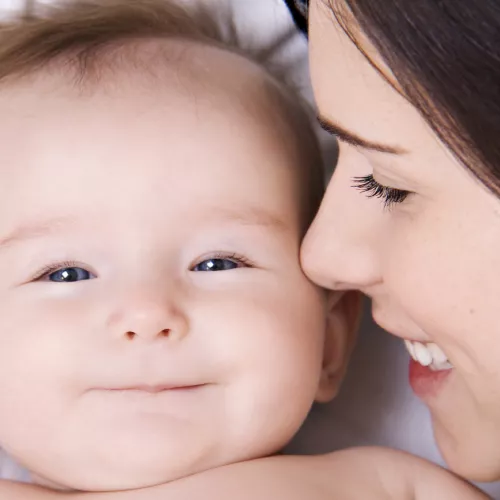 A woman smiling at a baby