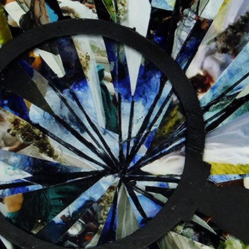 A collage of a shattered magnifying glass, made from photos and card. 