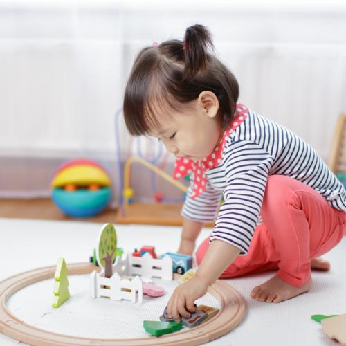 A toddler plays with a train set
