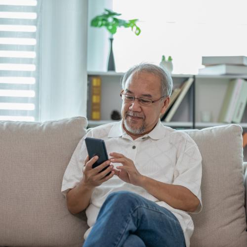 Man on the couch looking at a smart phone