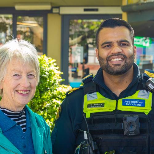 Older women stand outdoors with 2 Victoria Police officers, all are smiling