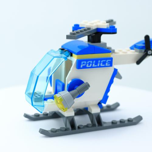 Blue and white helicopter made with lego pieces. Police is displayed on the side of the helicopter.