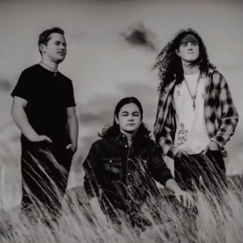 Three young men standing in a field