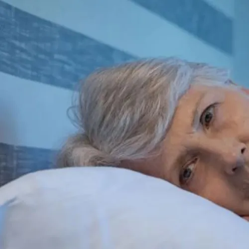 a tired and worried woman rests on a pillow