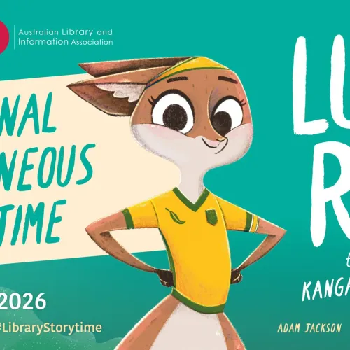 A cartoon figure of a kangaroo wearing a soccer shirt is standing in front of an aqua background