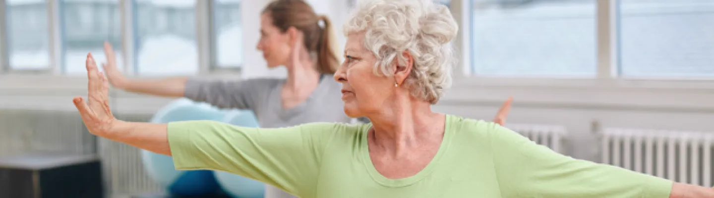 Two women stretch out in a yoga pose