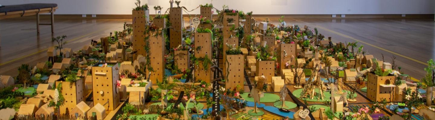 a miniature city covered in plants and animals
