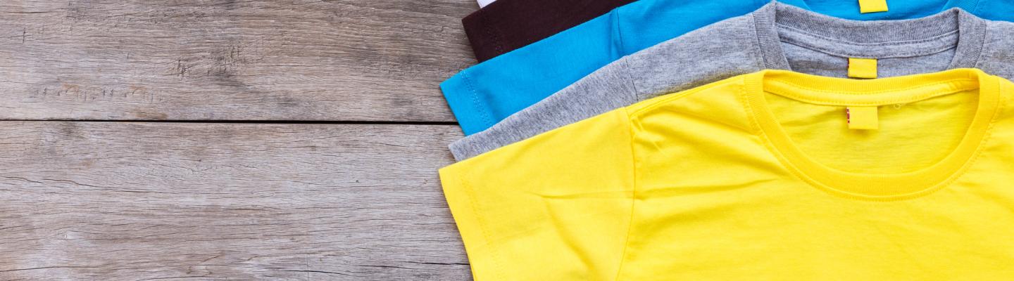 Row of coloured t shirts on a table
