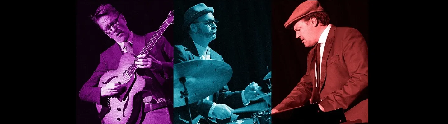 The 3 men of the Jake Mason Trio playing instruments