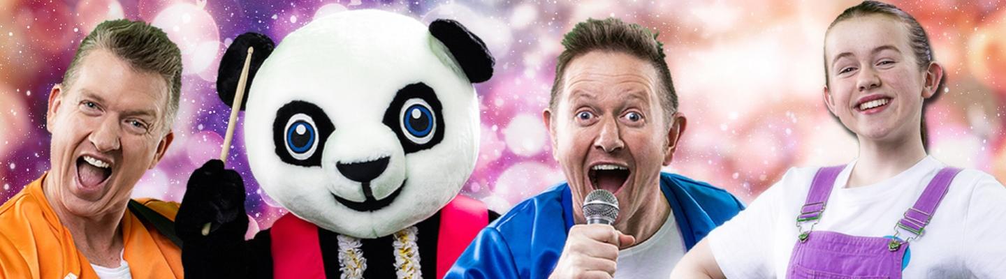 Two adults singing, one with a microphone, a young person smiling, and a panda with drumsticks
