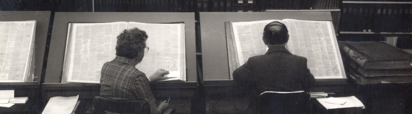 Old black and white image of two people reading in the State Library of Victoria