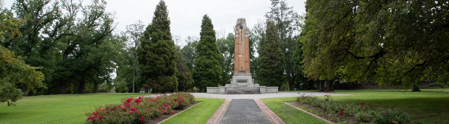 a cenotaph surrounded by neat lawns and cypress trees
