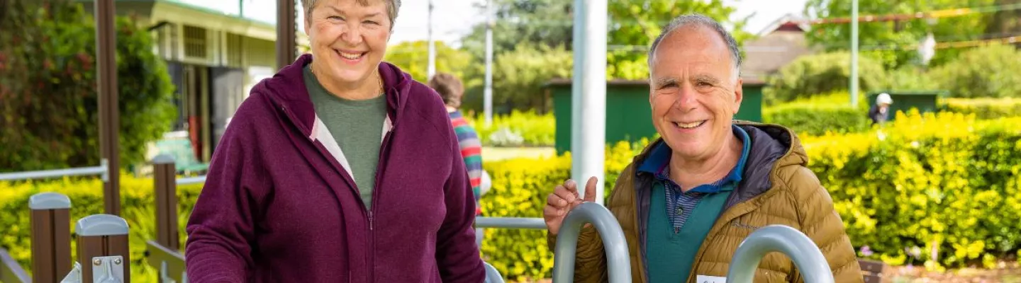older man and woman with exercise equipment in outdoors