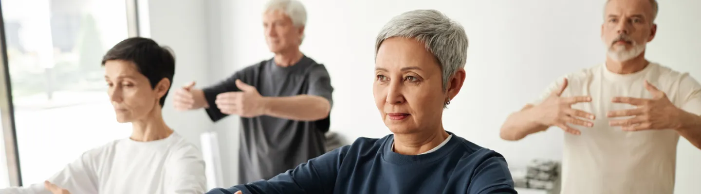 Four people in a room practising QiGong