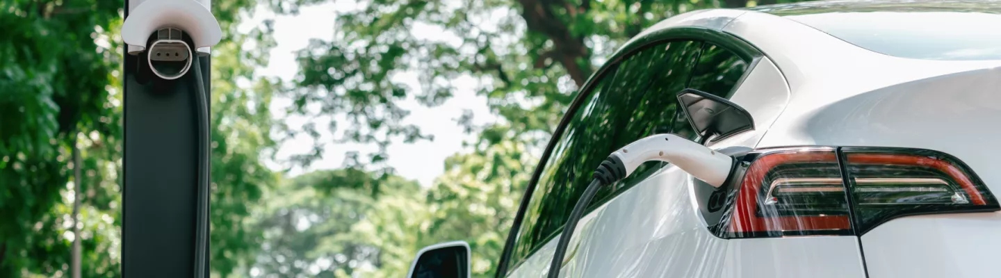 A white electric vehicle is charging