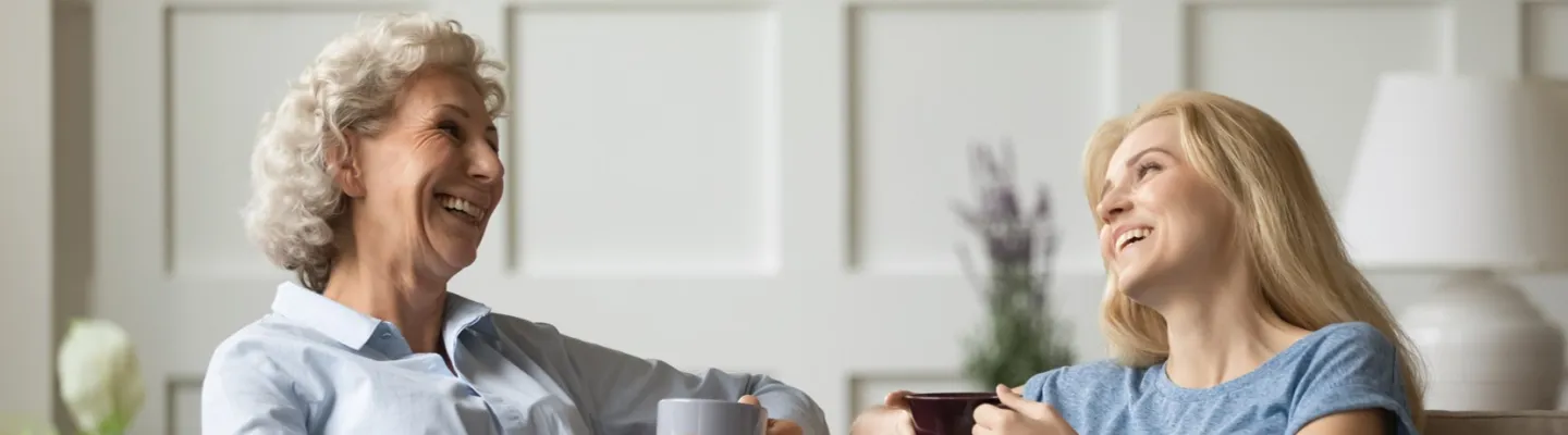 An AI image of two women sitting, having a cup of tea in their living room.
