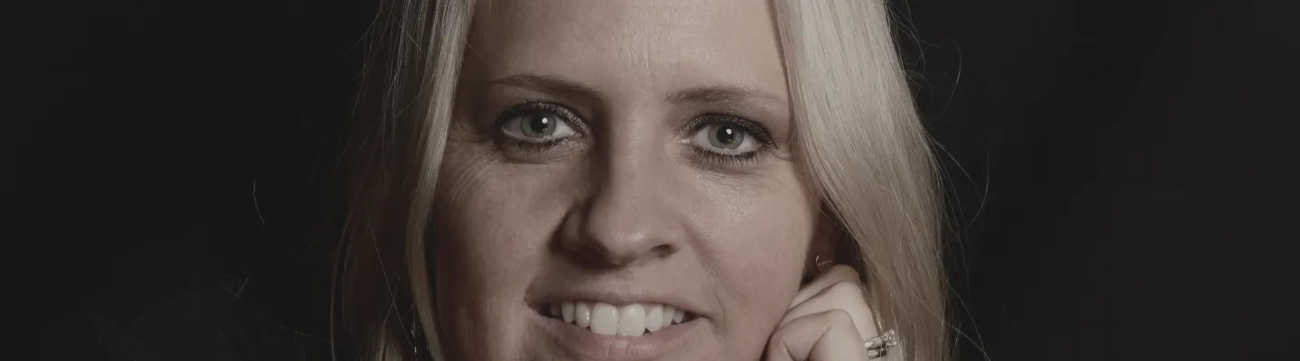 A blonde-haired woman smiles at us