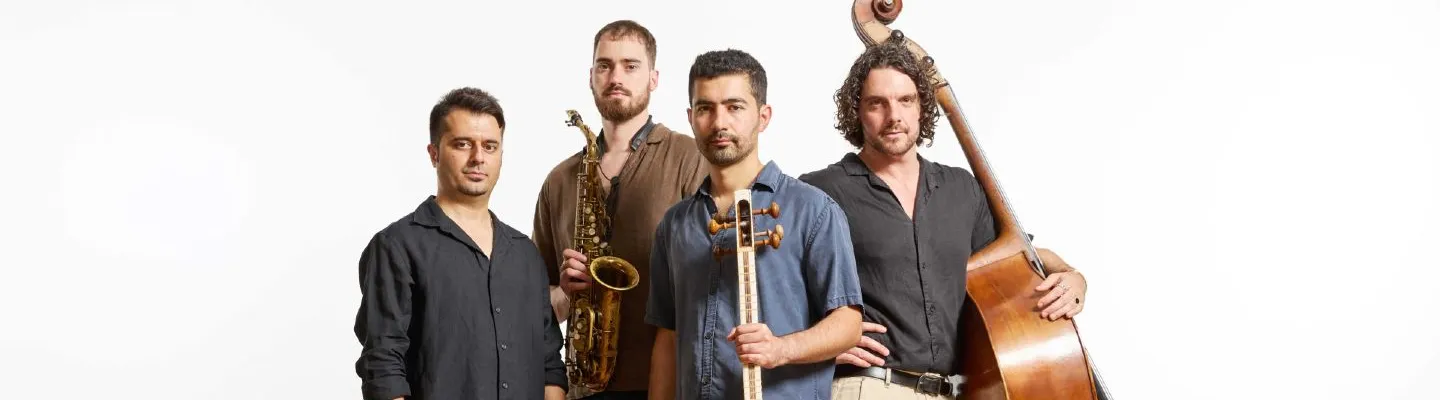 Four musicians standing together holding their instruments