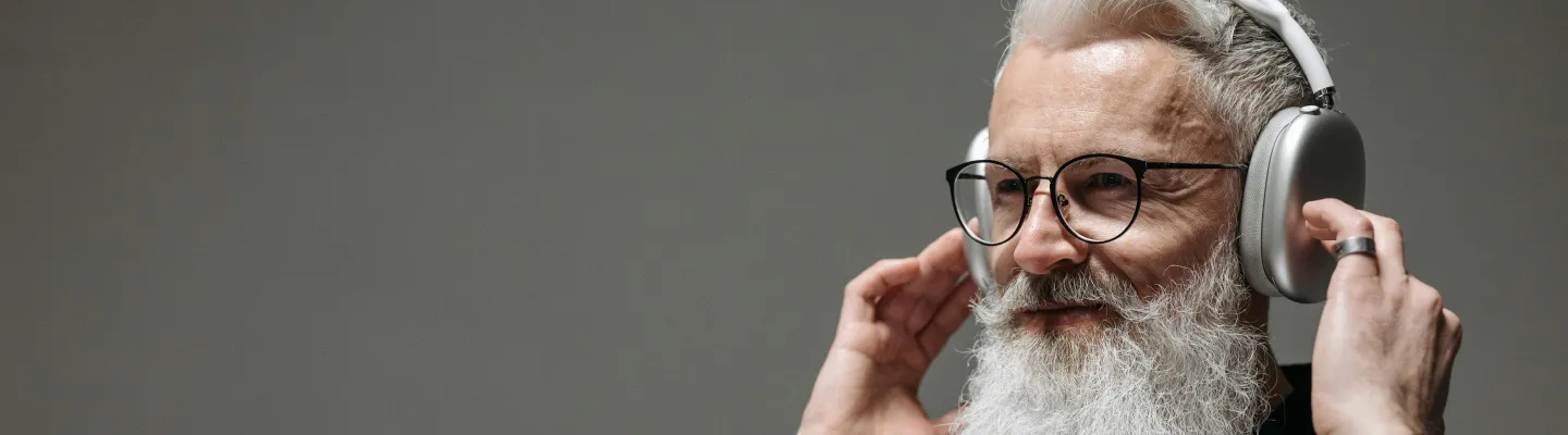 A bearded man is wearing wireless headphones