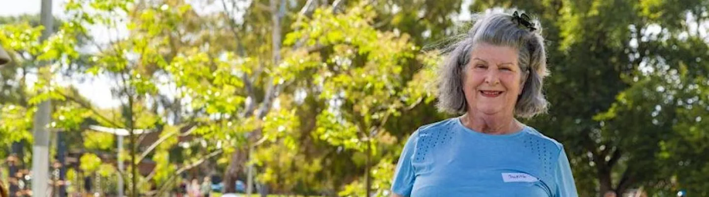 An older woman at an exercise station in a park