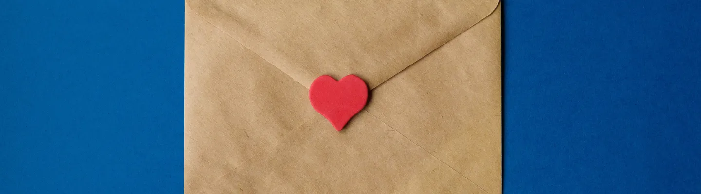 picture of a brown paper envelope with a red love heart seal. The background is dark blue.
