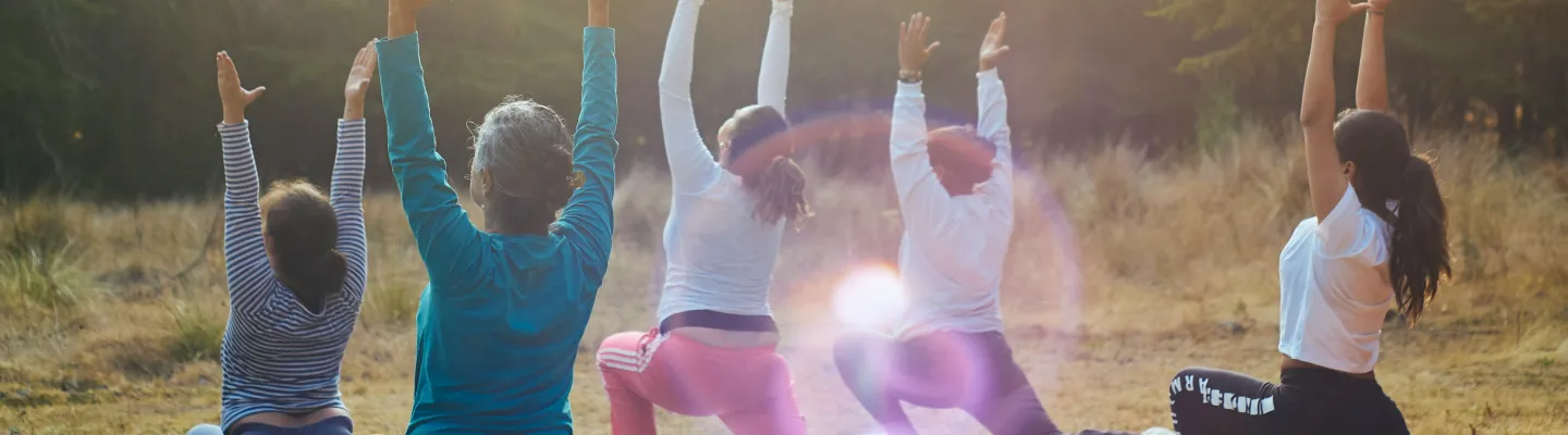 A group of people are doing yoga in a park