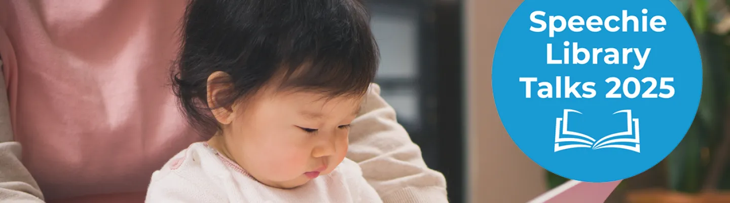A young child looks at an open book