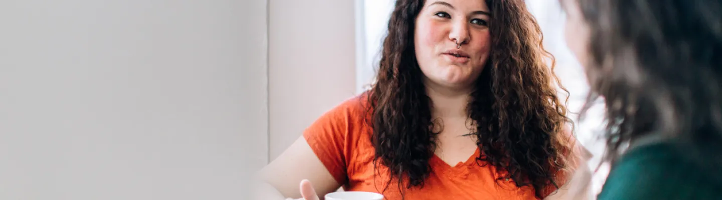 Two women have a cup of tea together.