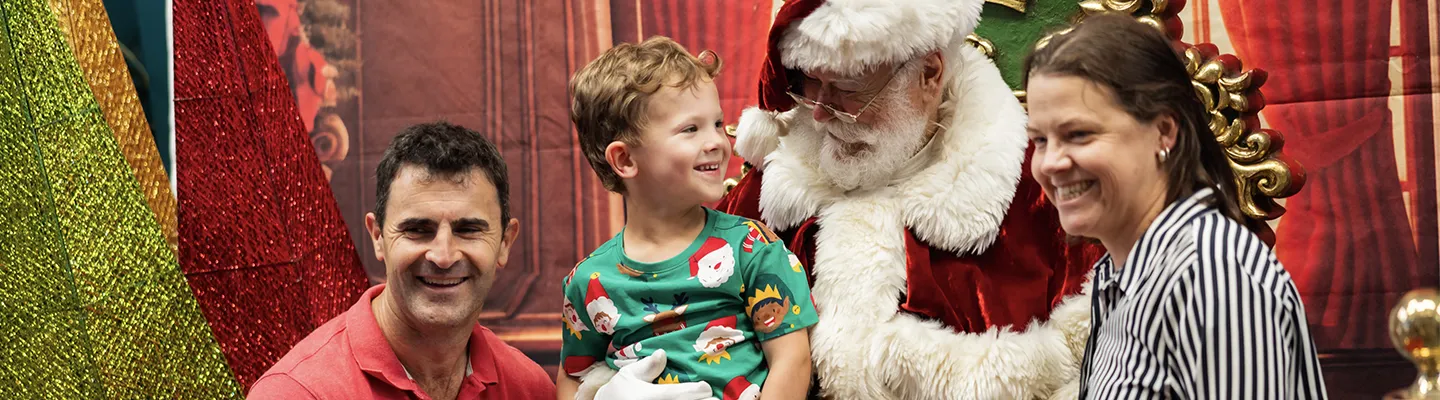 A family sit for a photo with Santa.