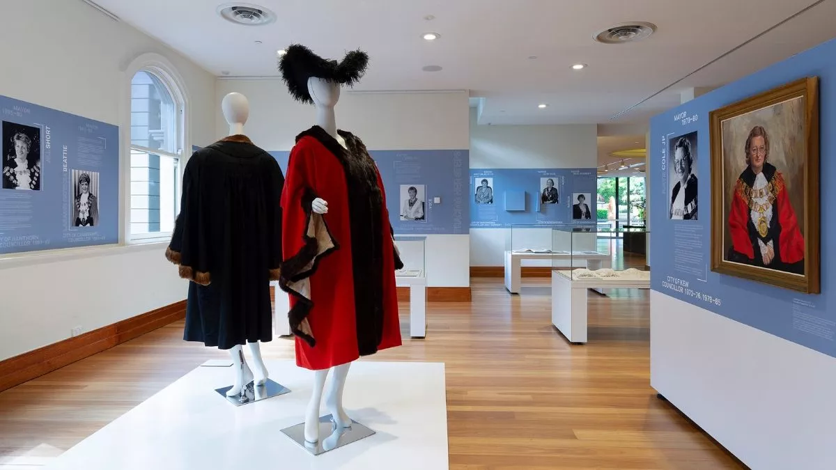 View of the Tracing Her Steps installation with two mannequins dressed in mayoral robes in the foreground