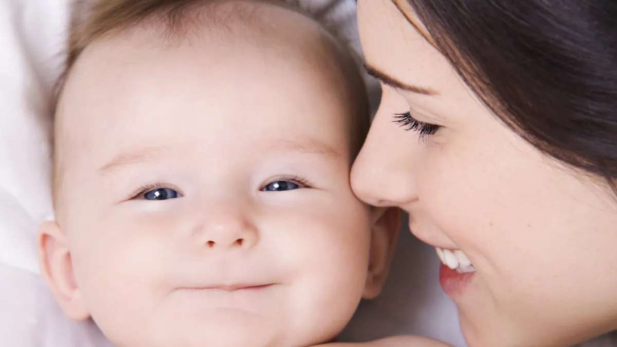 A woman smiling at a baby