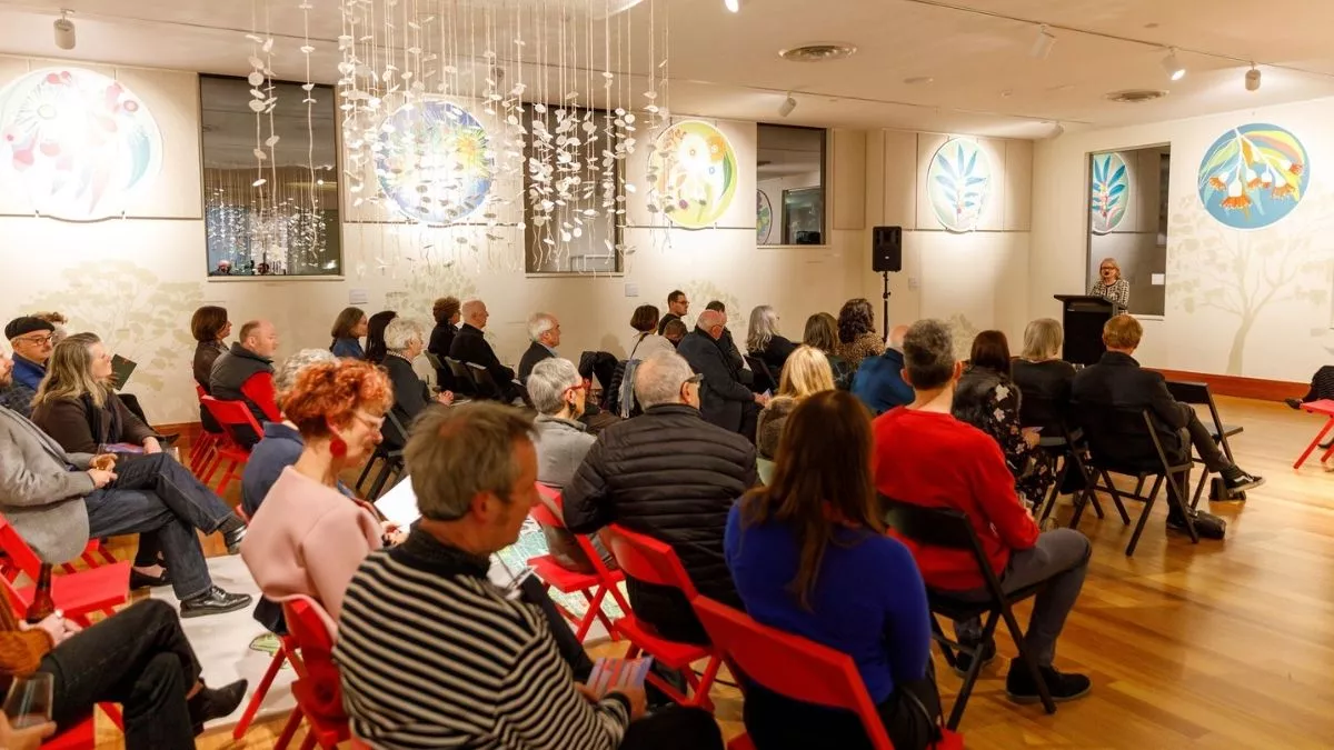 Visitors to 'Light Gestures' listing to a speech by Councillor Jane Addis. 