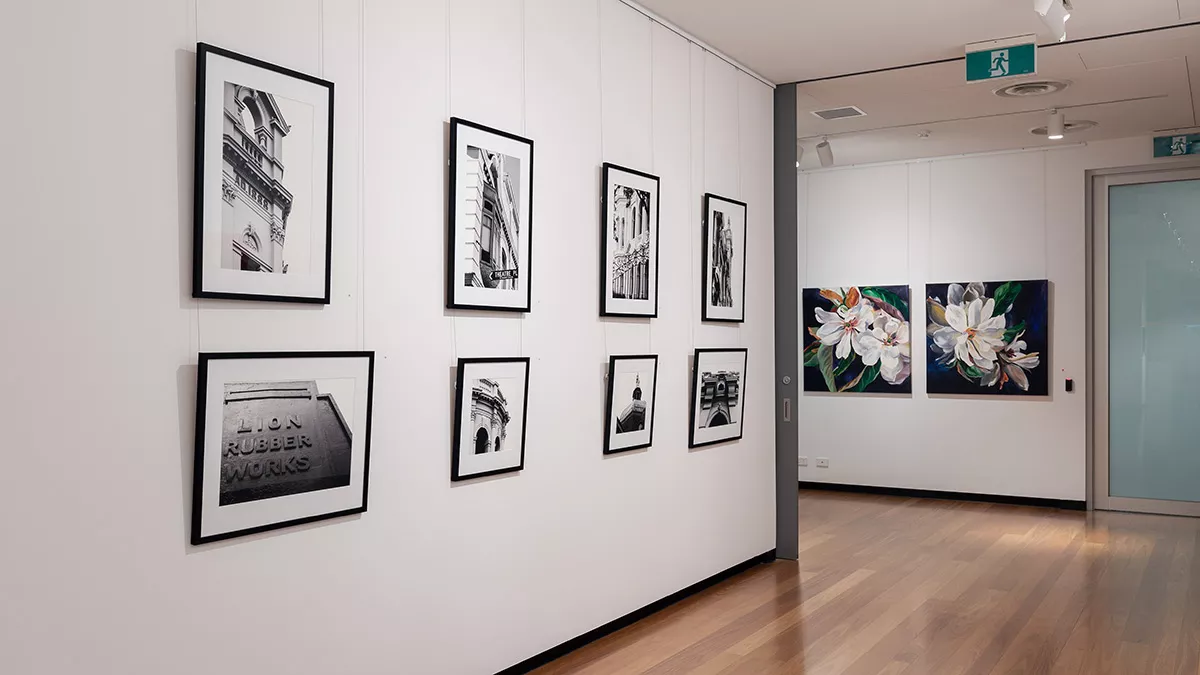 Installation view of 'Natural Constructs' at Town Hall Gallery. Close up paintings flowers by Shani Alexander on on side and photographs of the ornamental details on historical buildings in Boroondara by Jon Saroglu on the other.