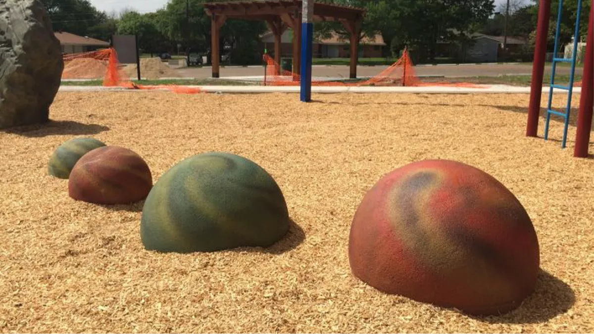 Planet spheres nestled in mulch at the Central Gardens playground renewal