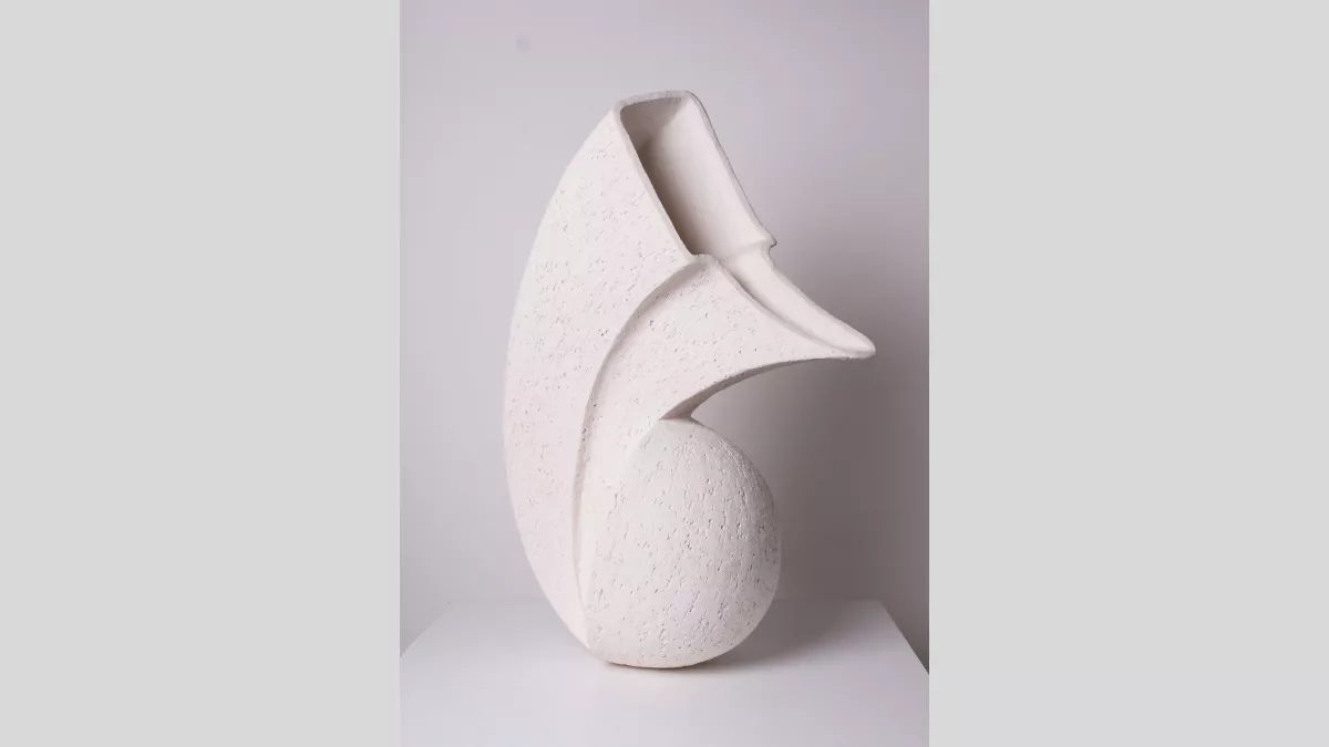 A stone vessel. Rounded at the bottom, and square and triangular at the top.