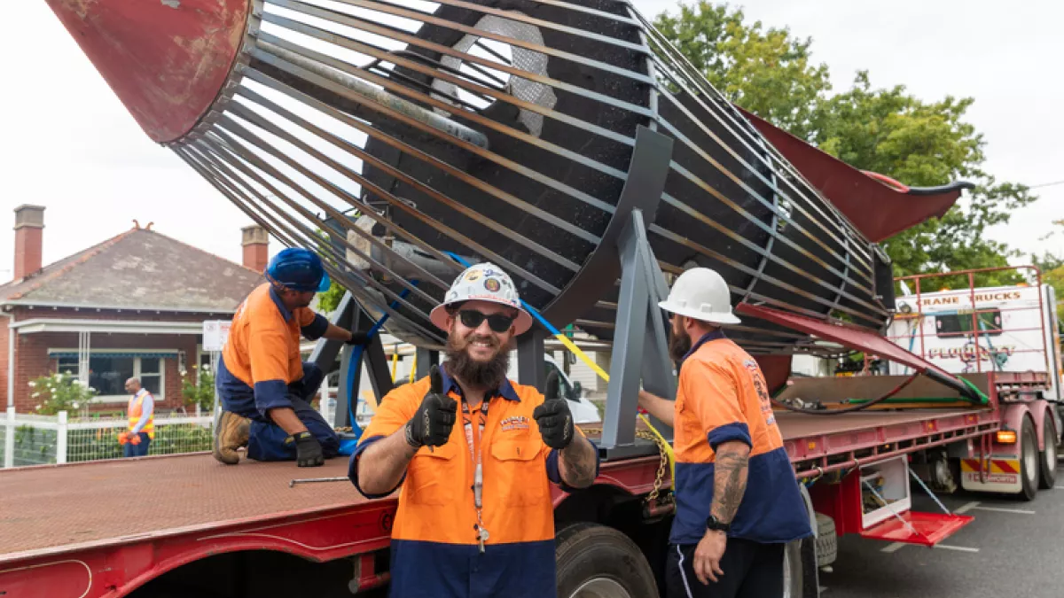 A playground rocket is strapped onto a flatbed truck for transporting
