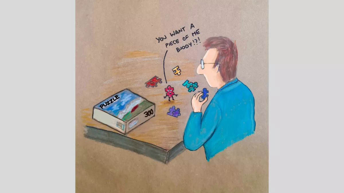 A drawing of a man sitting at a table with a puzzle box on it and puzzle pieces, and one of the pieces is saying to him 'You want a piece of me buddy!?'