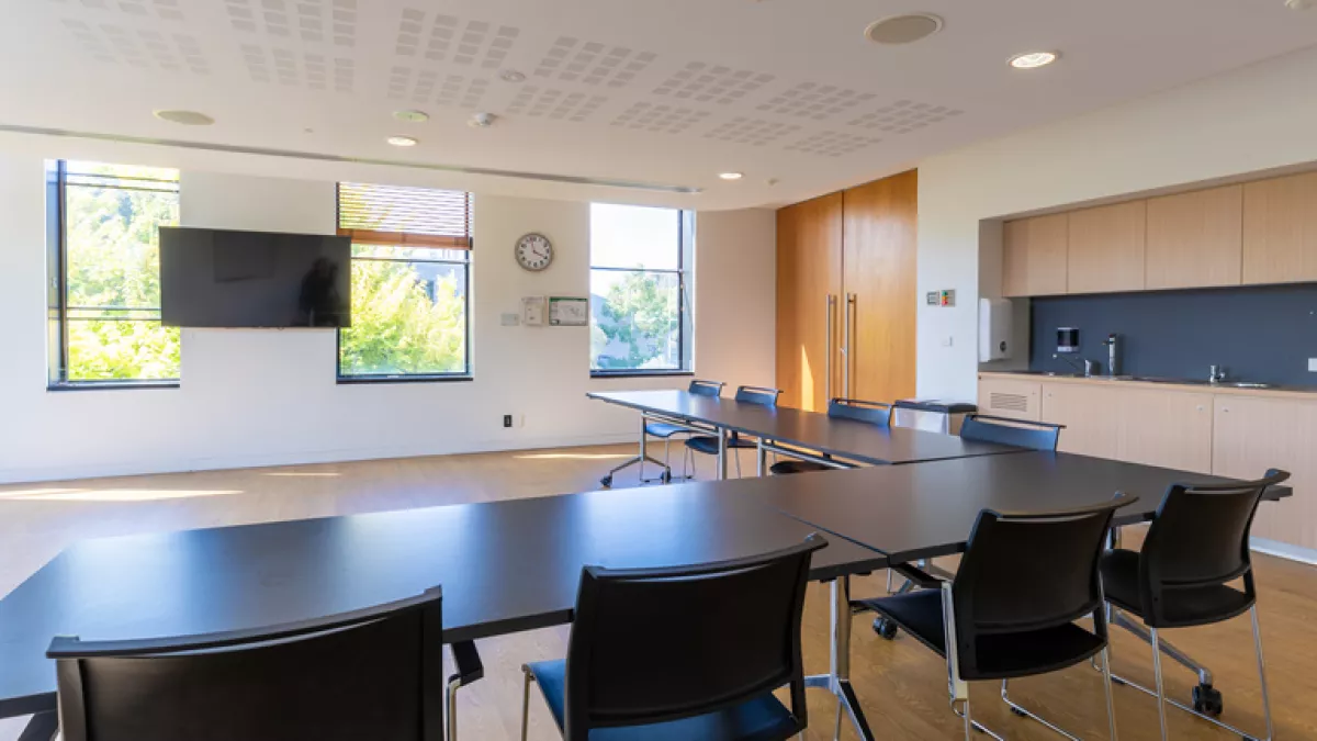 View from a meeting room table towards a wall-mounted TV