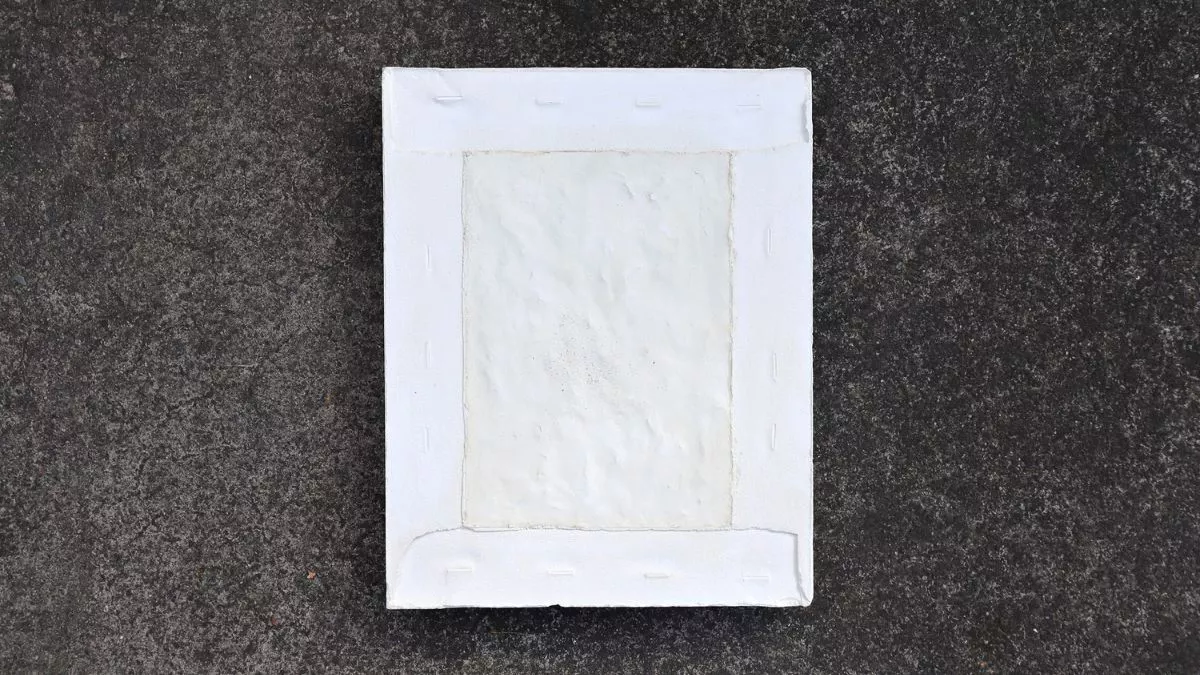 A ceramic artwork of a white rectangle with textured surface