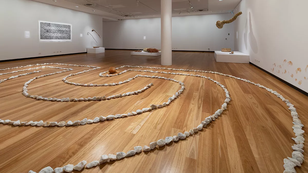 small rocks arranged in a spiral shape on a timber floor