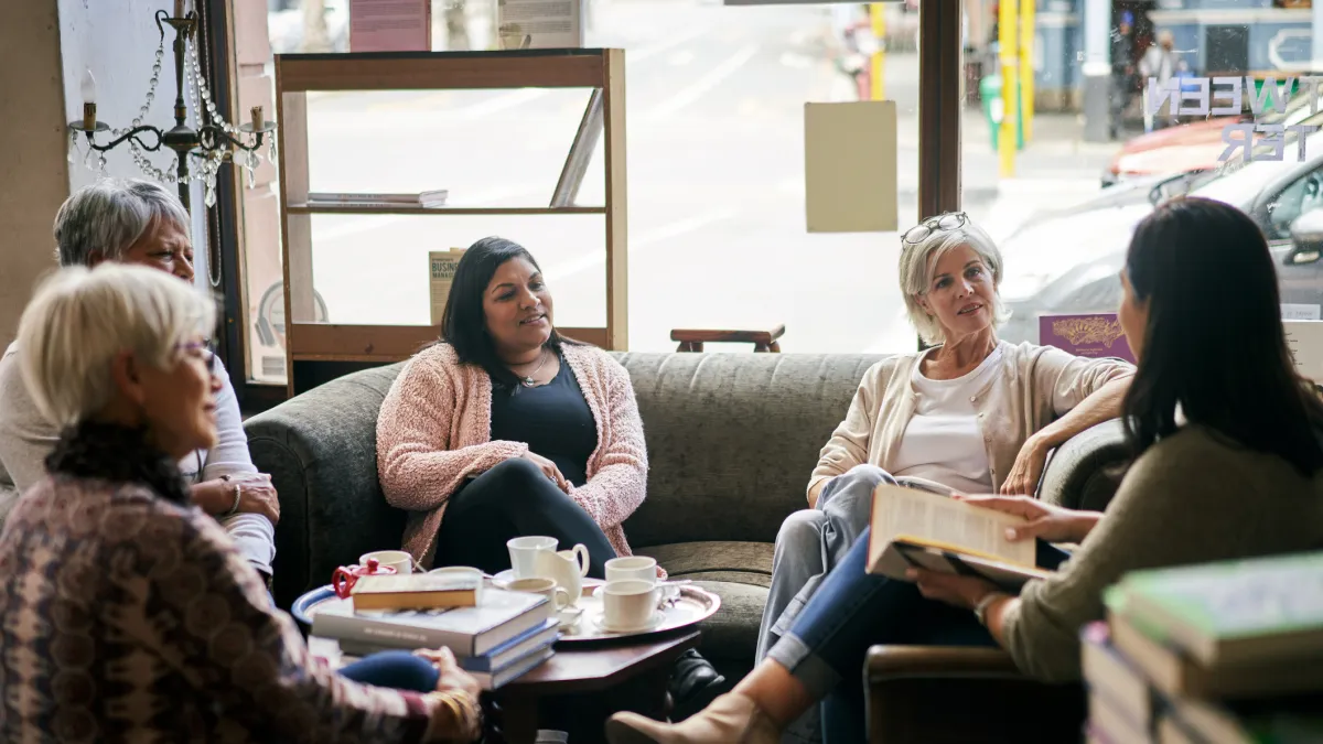 5 people sitting on couches holding books